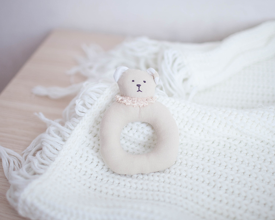 Baby's rattle on a baby blanket. Therapy for infertility, pregnancy loss, postpartum challenges, parenting